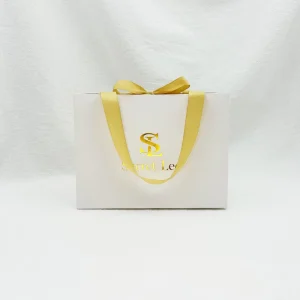 Bolsa de papel de cartón blanca de lujo personalizada con logo en foil dorado para empaquetado de regalos de ropa y prendas con asa