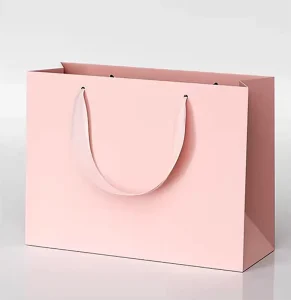 Bolsa de papel de regalo de lujo laminada negra personalizada impresa para ropa con asas de cinta